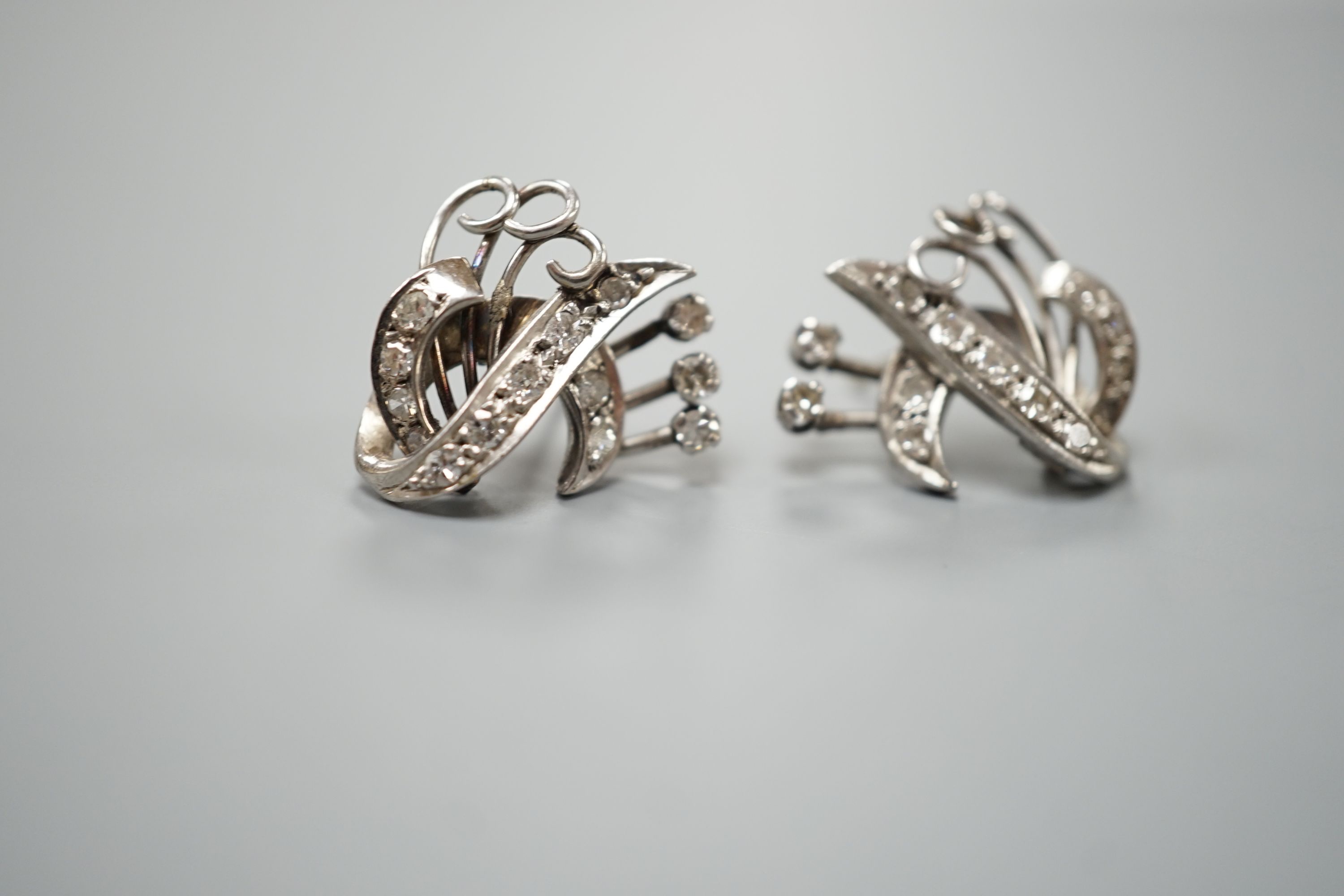 A pair of 20th century white metal and diamond cluster set fan scroll earrings(lacking butterflies), 15mm, gross weight 8 grams.